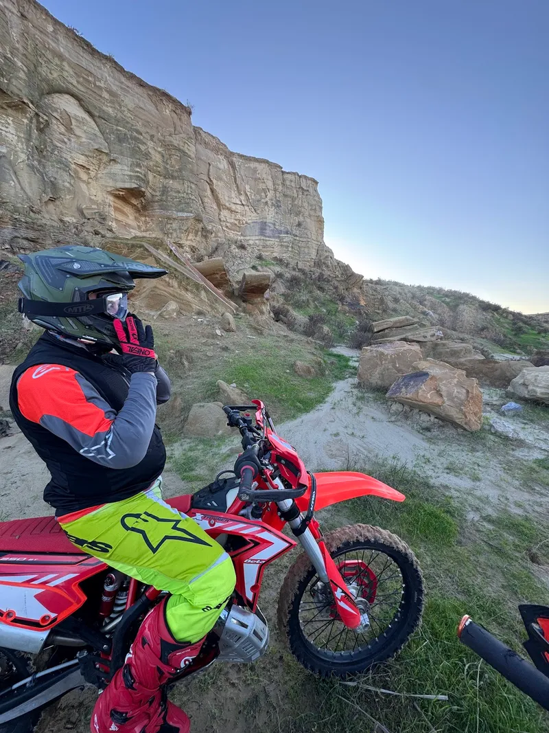 Kayalık bir vadide kırmızı enduro motosikleti üzerinde sürücü